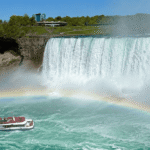 Niagara Falls boat tour passing below the Falls with rainbow and mist