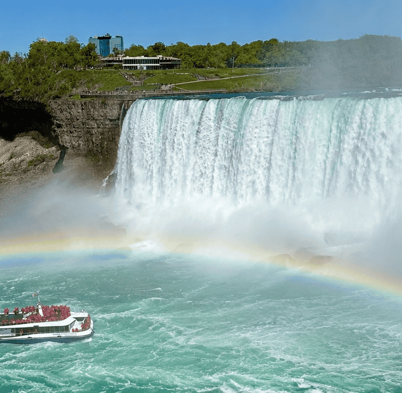 Niagara Falls boat tour passing below the Falls with rainbow and mist